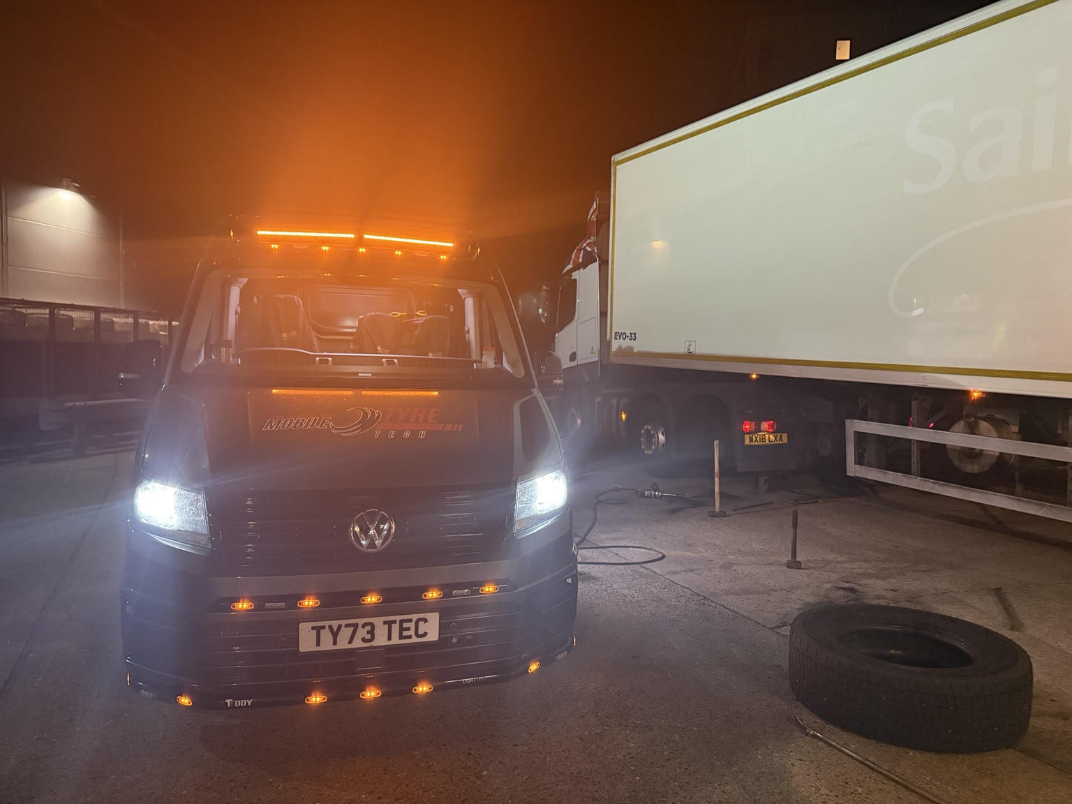 Mobile Tyre Tech van with amber lights beside a lorry at night